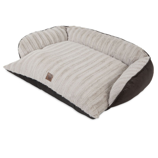 The Snoozzy Rustic Luxury Comfy Couch Pet Bed is a plush, rectangular bed with raised cushioned sides. It features cream ribbed fabric on top, dark sides, a brown front label, and is machine washable for convenience.